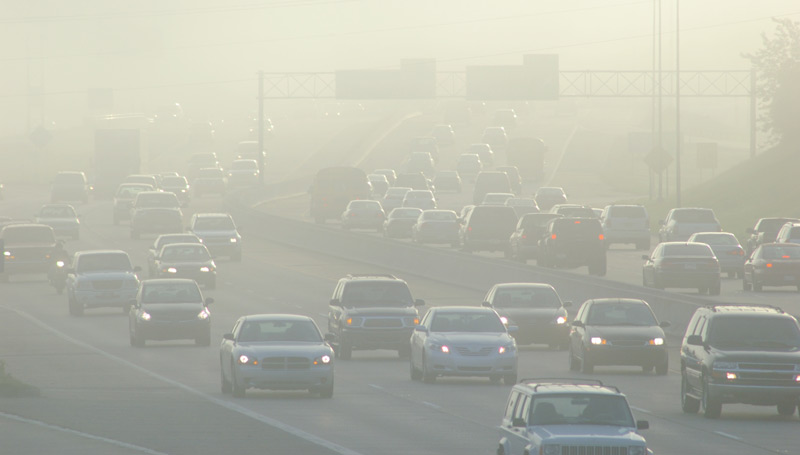 cars driving on the freeway through thick smog