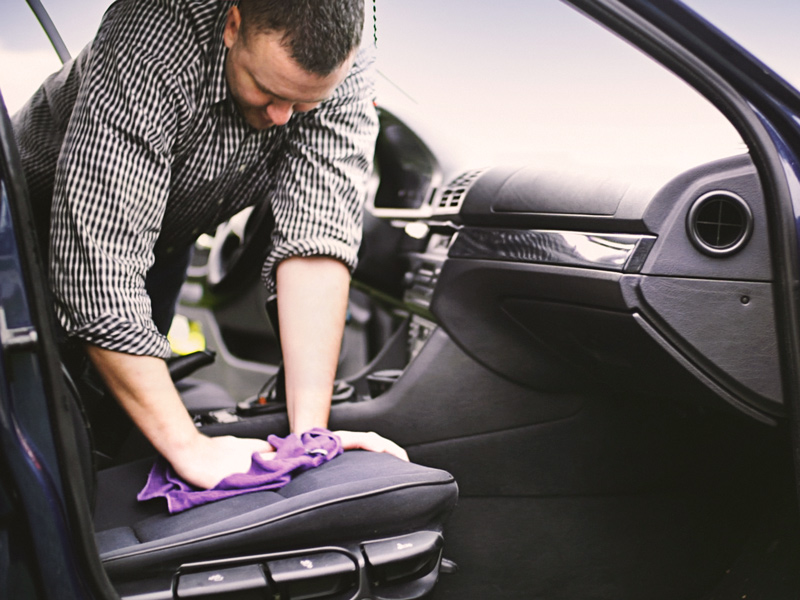 Man blotting car seat with towel