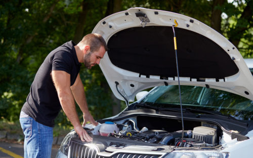 Man looking under the hood of his car