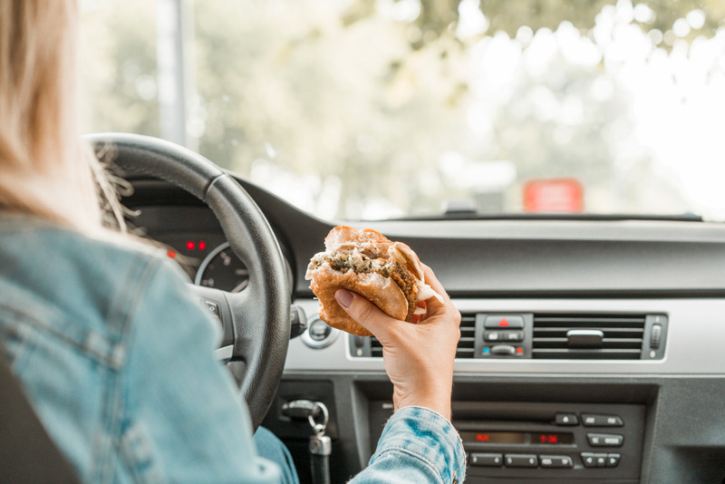 woman eating a burger in the car