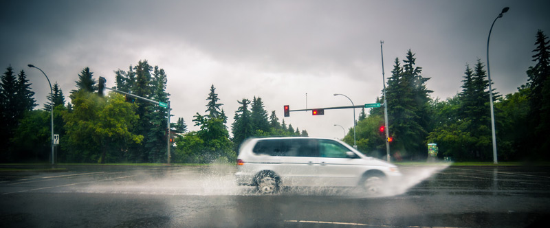 Van driving through water on street