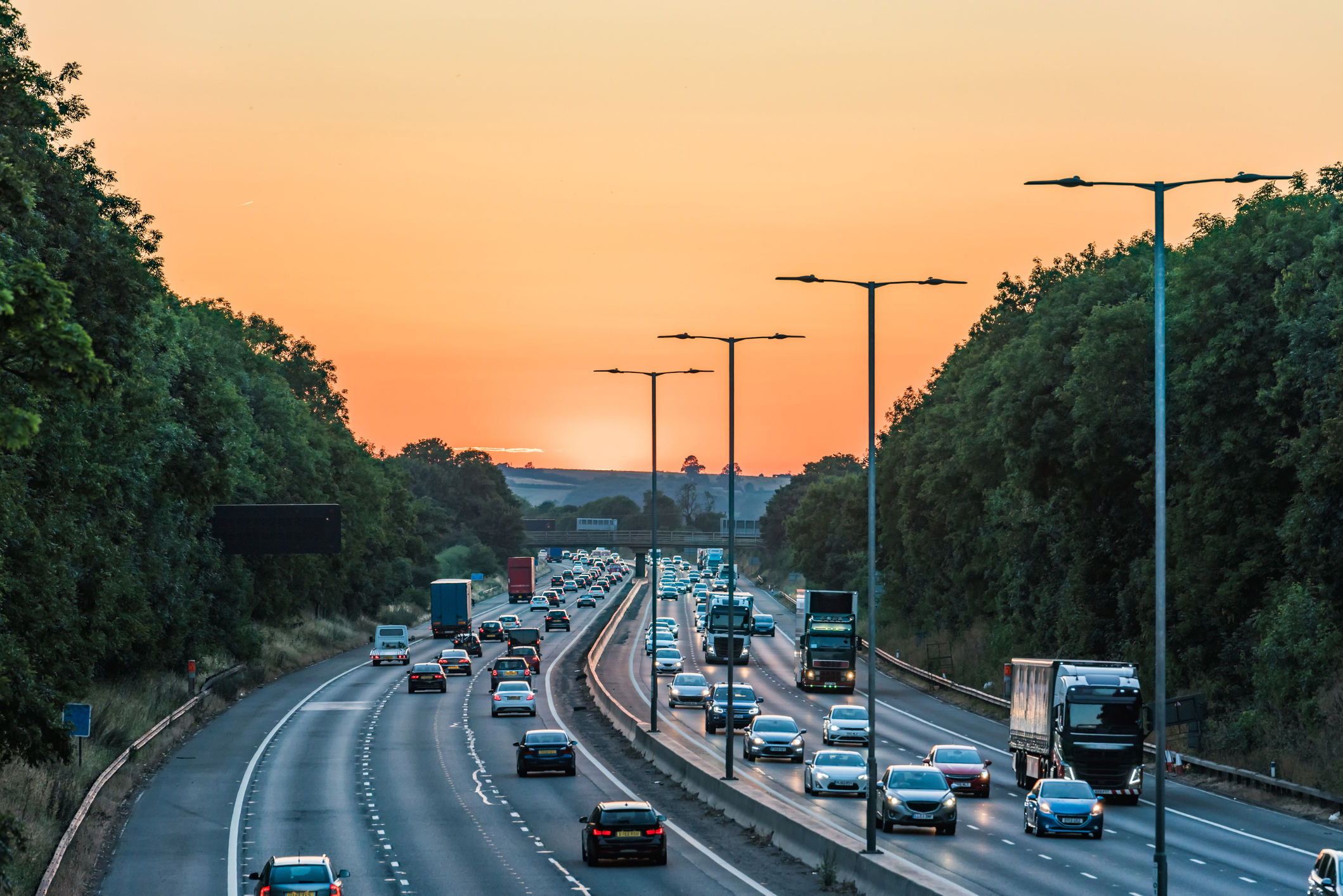 Sunset view of busy UK Motorway traffic in England Cars and trucks driving on busy freeway