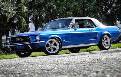blue driving 1967 Ford Mustang