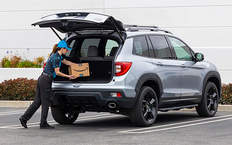 Woman putting an Amazon box in trunk