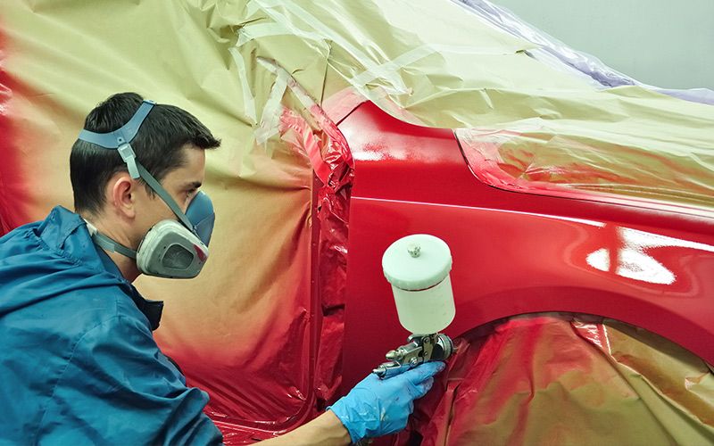 Painting car with a gravity fed pneumatic paint sprayer Painting car with a gravity fed pneumatic paint sprayer