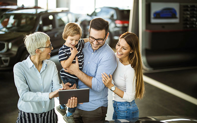 Family discussing car options with a dealer