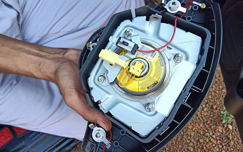 Steering wheel airbag inflator