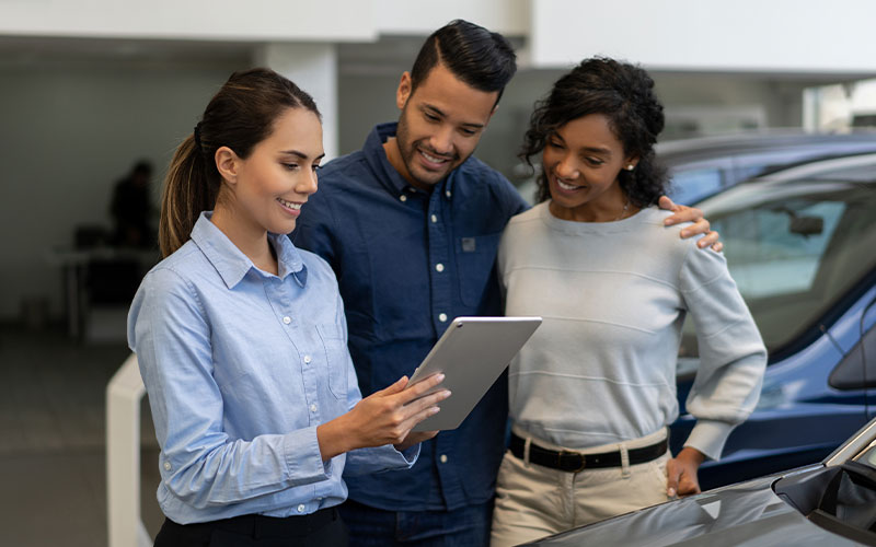 Couple discussing options with saleswoman Couple discussing options with saleswoman