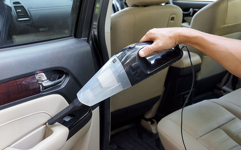 Person vacuuming their vehicle