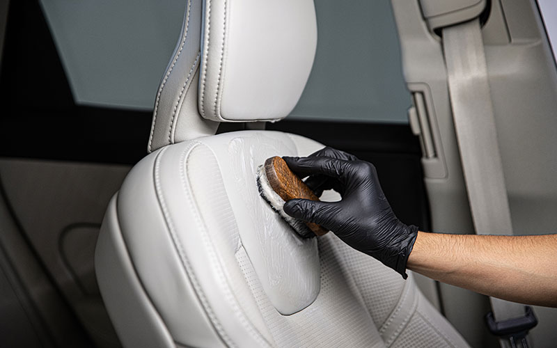 Person scrubbing leather upholstery