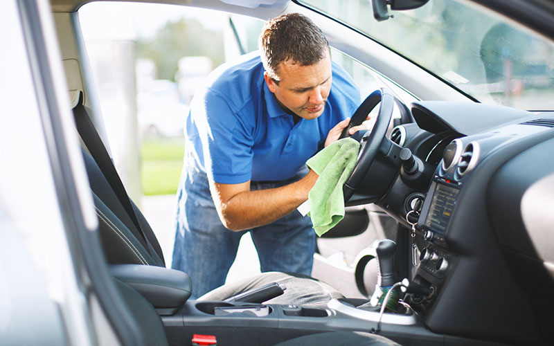 Car owner cleaning his car interior