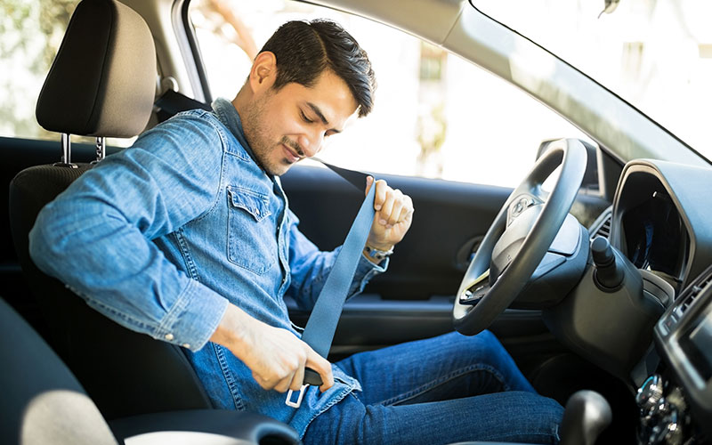 Driver putting on a seatbelt