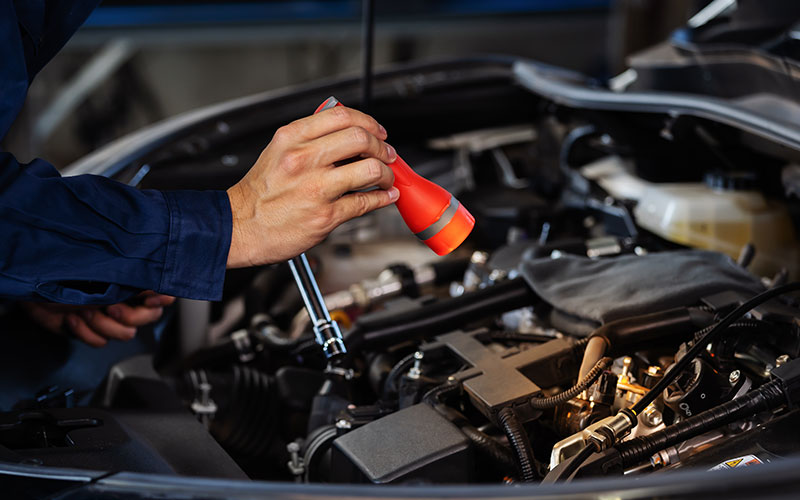 Using a flashlight to inspect a vehciel
