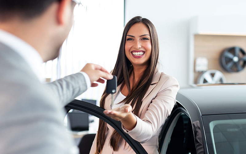 Woman receiving new car keys