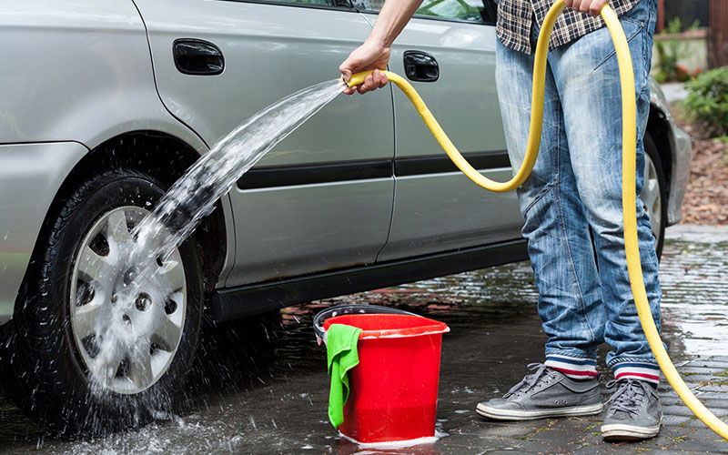 Person washing their car at home