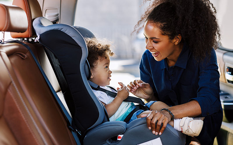 Mom buckling child into carseat Mom buckling child into carseat