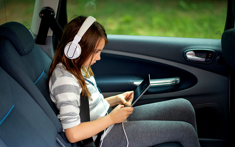 Young girl wearing headphones in the car Young girl wearing headphones in the car
