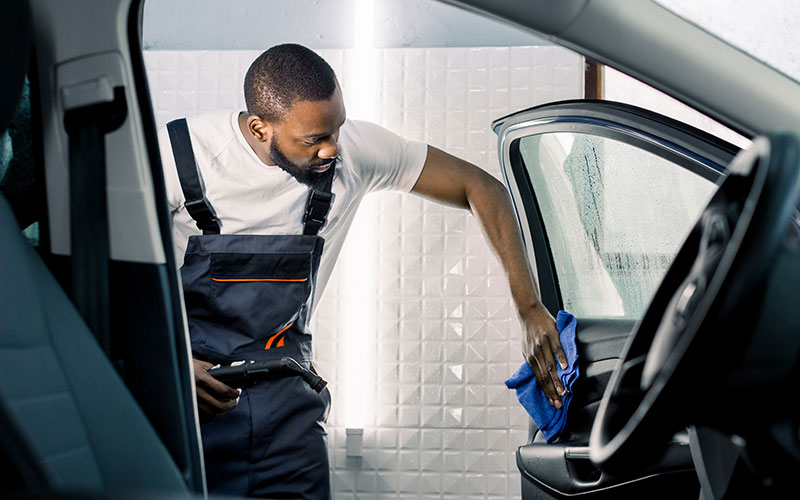 Man detailing the inside of his car Man detailing the inside of his car