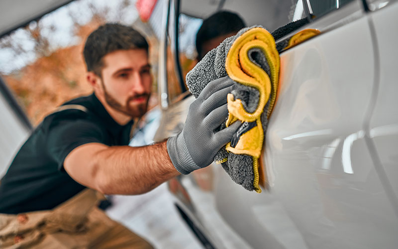 Man wiping down the outside of his car Man wiping down the outside of his car