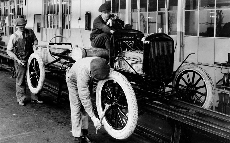Men working on Model T assembly line - media.ford.com