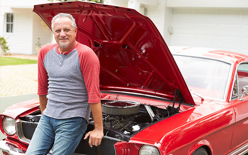 Man standing next to his project car