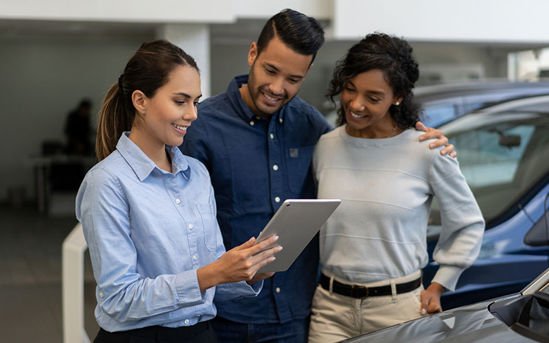 Saleswoman showing vehicle information Saleswoman showing vehicle information