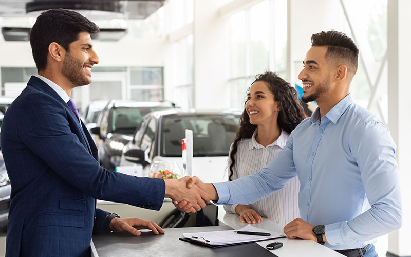 Salesperson and car buyer shaking hands Salesperson and car buyer shaking hands