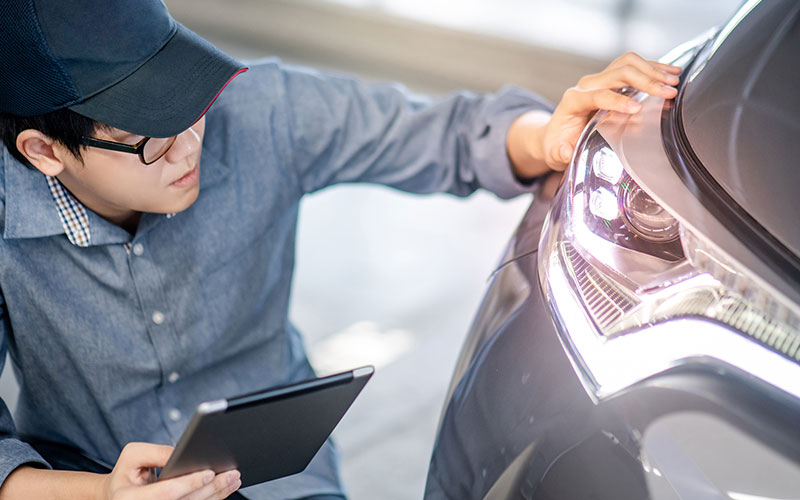 Inspecting headlights on a car Inspecting headlights on a car