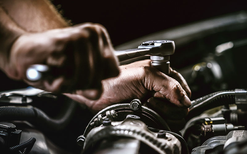 Man using a wrench on a car