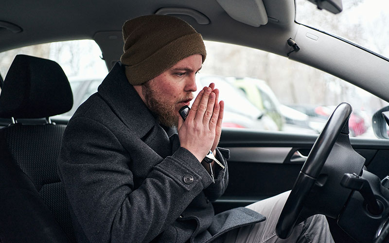 Man trying to warm up in his car
