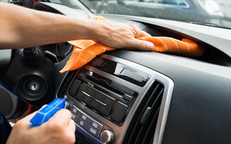 Wiping down car dashboard Wiping down car dashboard