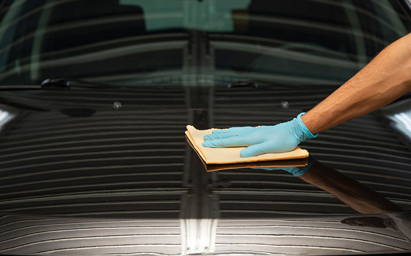 Person waxing their car Person waxing their car