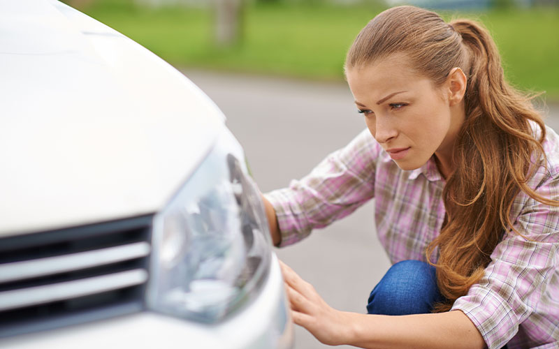 Woman examining car Woman examining car