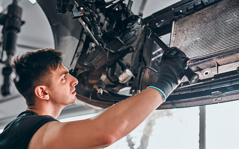 Mechanic examining radiator Mechanic examining radiator
