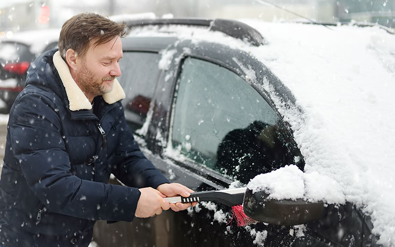Man cleaning snow off car Man cleaning snow off car