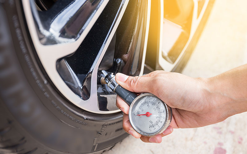 Checking tires with pressure gauge