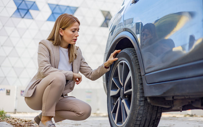Woman inspecting tire