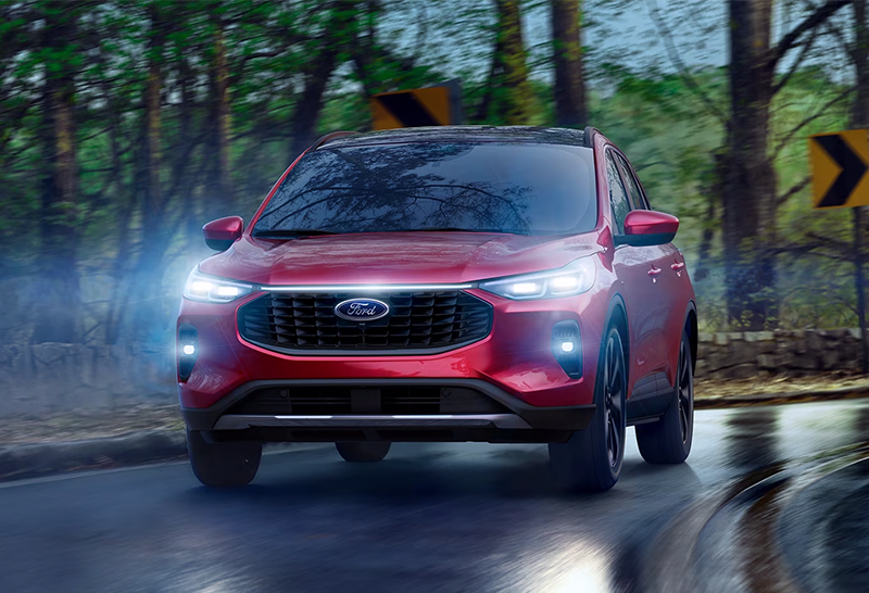 2024_Ford_Escape a red 2024 Ford Escape driving on a rainy road
