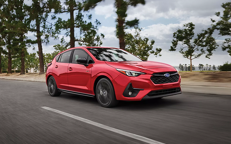 a red 2025 subaru impreza driving