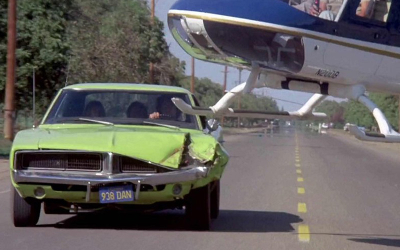 A greenish-yellow 1973 Pontiac Ventura behind a helicopter during a car chase in the movie "Dirty Mary, Crazy Larry"