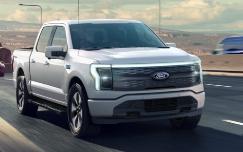 A white Ford F-150 driving on an Interstate