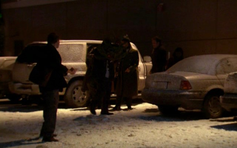 People pile into a snow covered 2002 Cadillac Escalade