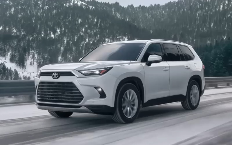 2026 Toyota Grand Highlander driving on a highway in the winter