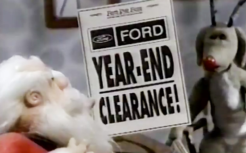 Santa looking at a Ford year-end clearance newspaper ad