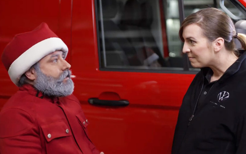 Santa and a Volkswagen tech in front of a red commercial van