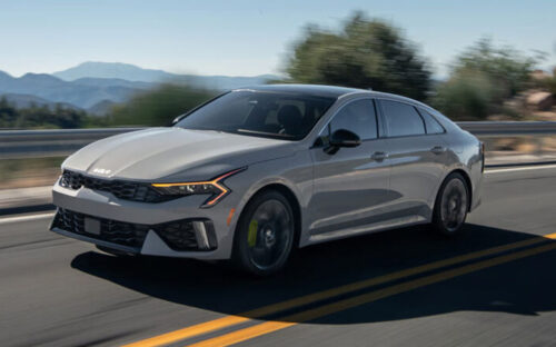 2026 Kia K5 driving down the road.