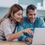A couple on a laptop buying a car