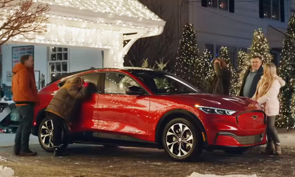 The Griswolds looking at a red Ford Mach-E