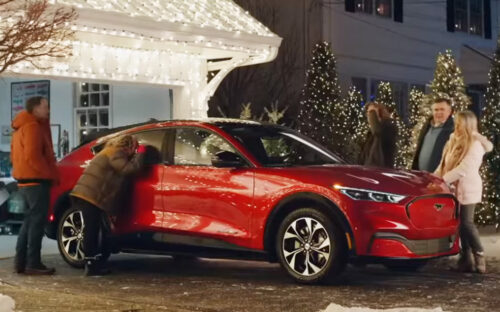 The Griswolds looking at a red Ford Mach-E