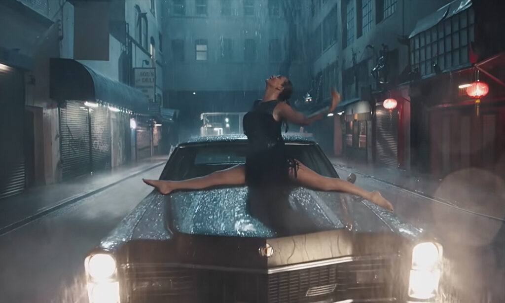 Taylor Swift in the splits on the hood of a 1967 Cadillac Fleetwood 60 Special